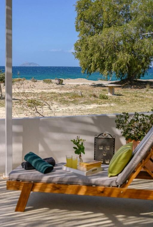 View of the sea from the patio of Paximadia Beachfront Apartment in Neo Kalamaki at sunset. The sky glows with warm colors, reflecting over the calm waters
