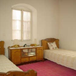 Cozy second bedroom of Sior Nikoletos with two single beds and traditional Cretan decor