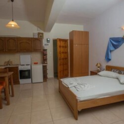 Bedroom with double bed and kitchnette at Sunset Holiday Apartment