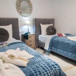 Bright bedroom with two single beds and fresh linens at Villa Virginia in Kalamaki, Crete.