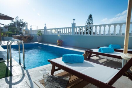 Private swimming pool with two sun loungers and rolled turquoise towels at Villa Virginia in Kalamaki.