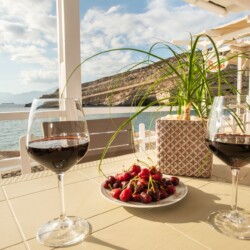 Sea view from private balcony in Matala with two glasses of red wine
