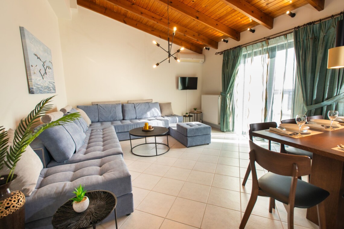 Spacious living area with sea view and large couch in Suite Thea